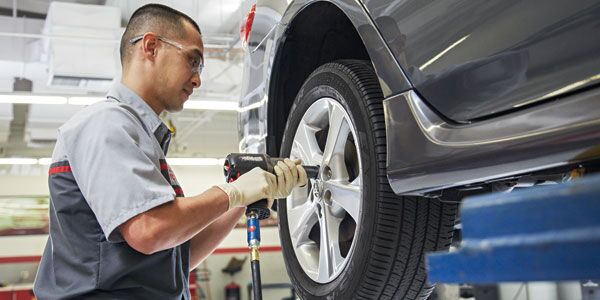 A Toyota technician changing a tire at Perry Motors Toyota in Bishop, CA 