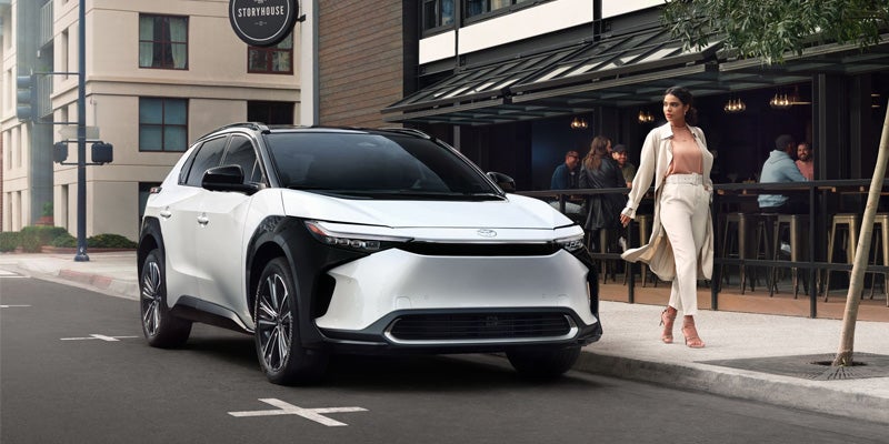 A woman admiring a 2024 Toyota bZ4X near Bishop, CA
