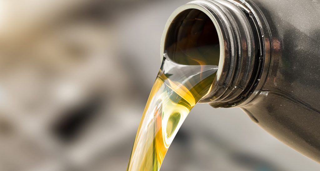 Close-up of motor oil being poured from a bottle.
