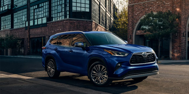 Blue Toyota Highlander parked on a city street.