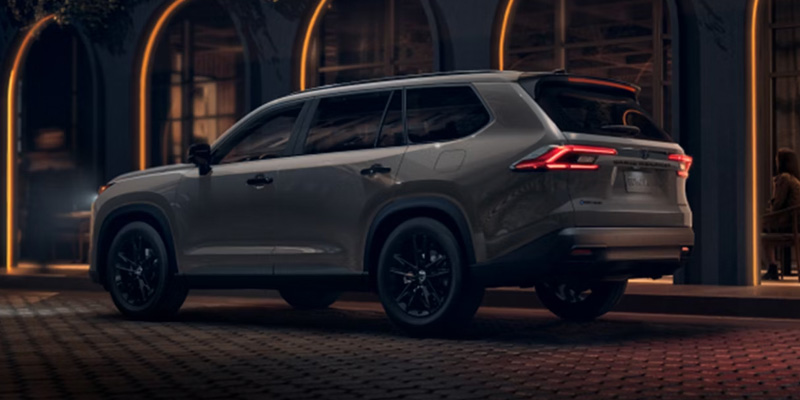 Gray Toyota Grand Highlander parked outside a building at night.