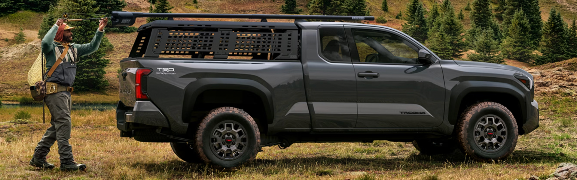 Dark gray Toyota Tacoma TRD PreRunner truck near a fisherman.